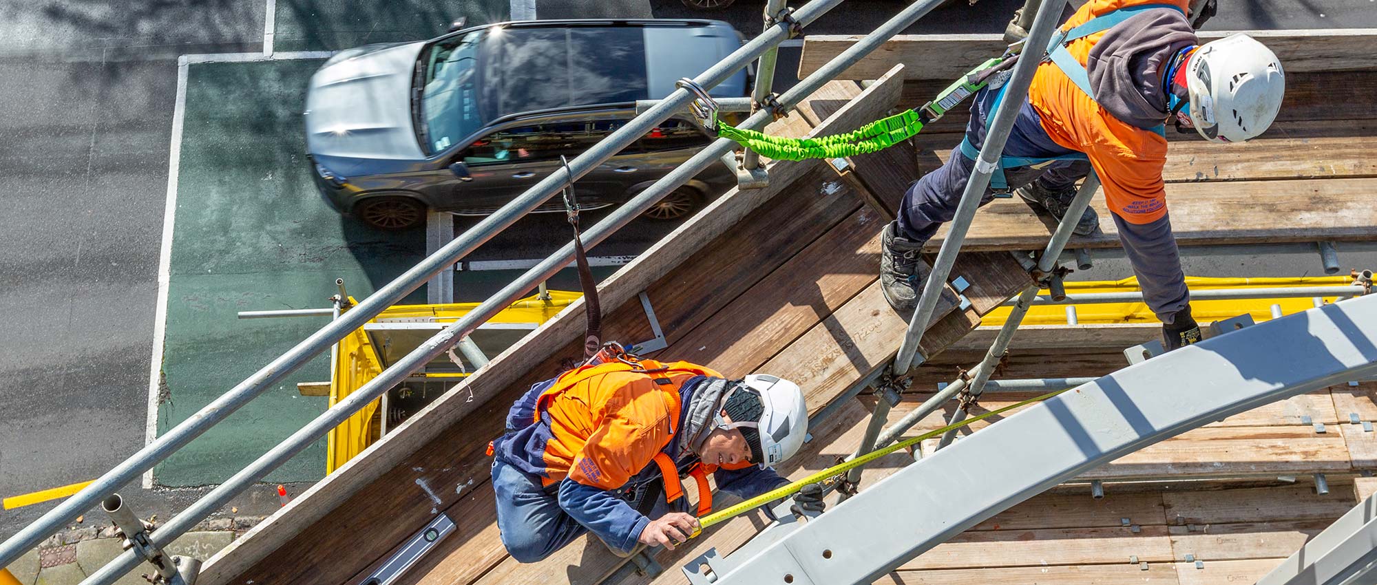 construction workers at height above the road