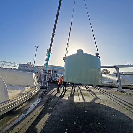 Crane at Māngere Splitter Box 1 ready to lift green tank