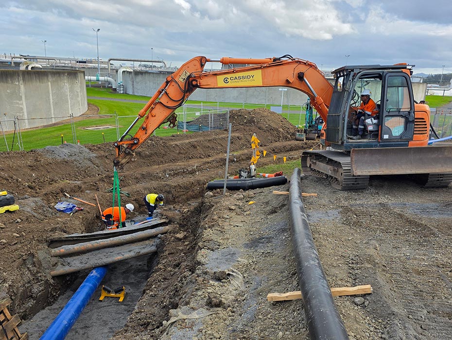 cassidy digger driver unloading potable water pipes to team in a trench