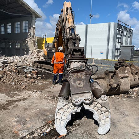 close up of demolition jaws attached to large excavator