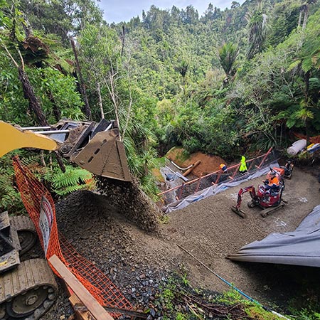 view looking down the steep bush-lined terrain during landslip remediation work